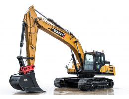 Excavator SANY SY265C prezentat pe fundal alb, cu cupă de mari dimensiuni și atașament de prindere rapidă roșu, brațul extins în poziție verticală.